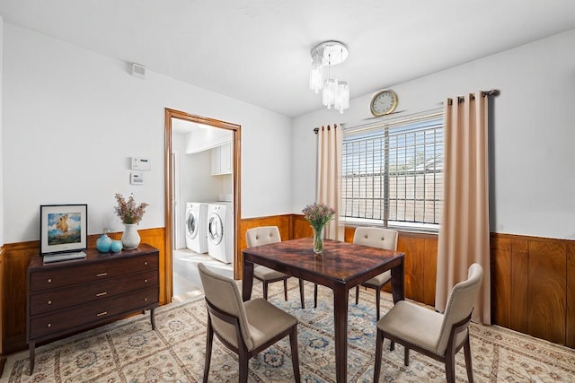 7718 Pella Dr, Houston, TX 77036 - dining area with wainscoting, a notable chandelier, separate washer and dryer, and wood walls