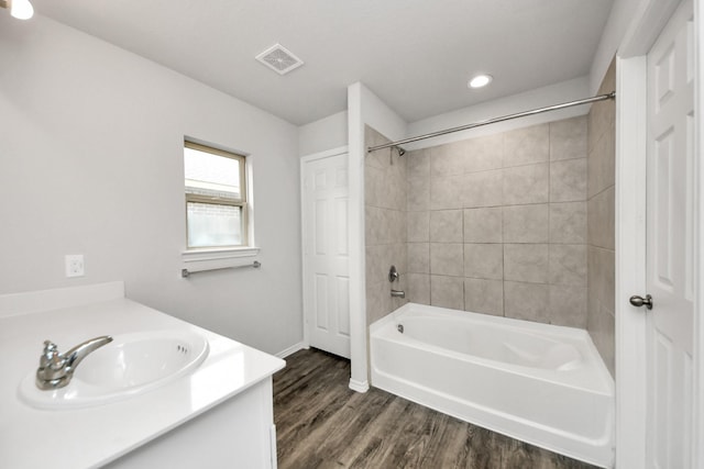 bathroom featuring recessed lighting, wood finished floors, baseboards, visible vents, and tub / shower combination