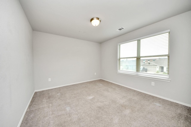 empty room with visible vents, carpet floors, and baseboards