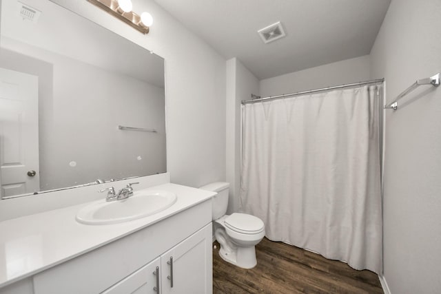 full bathroom featuring toilet, wood finished floors, visible vents, and vanity