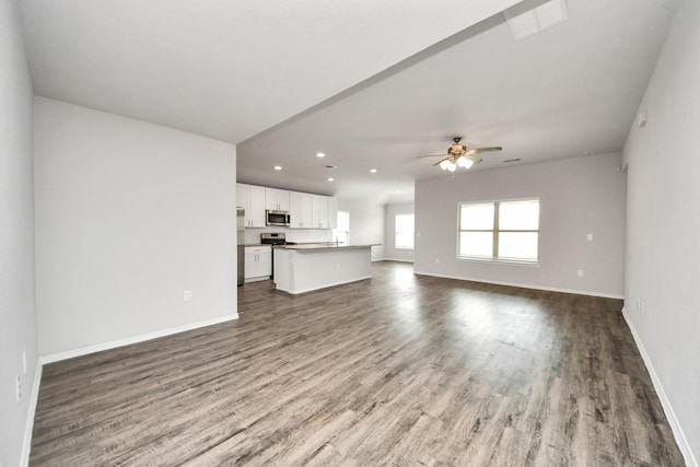 unfurnished living room with wood finished floors, ceiling fan, recessed lighting, and baseboards