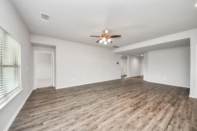 unfurnished living room featuring wood finished floors, a ceiling fan, visible vents, and baseboards