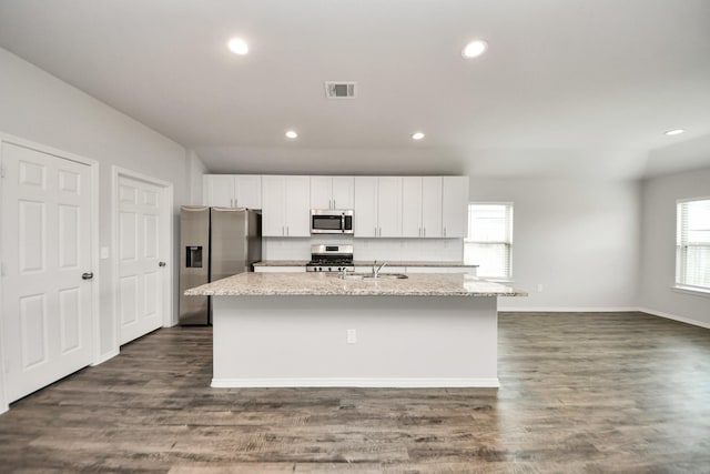 kitchen with white cabinets, a sink, visible vents, stainless steel appliances, and an island with sink