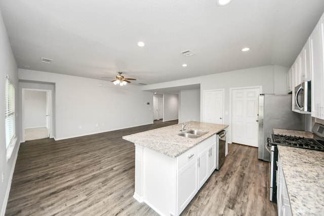 kitchen with stainless steel appliances, ceiling fan, a sink, white cabinetry, and a center island with sink