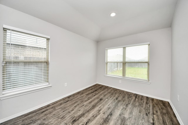 spare room with wood finished floors, recessed lighting, vaulted ceiling, and baseboards