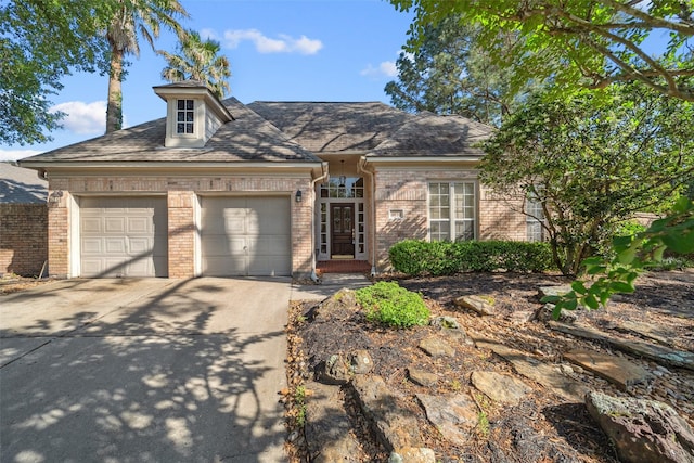 traditional home featuring concrete driveway, an attached garage, and brick siding