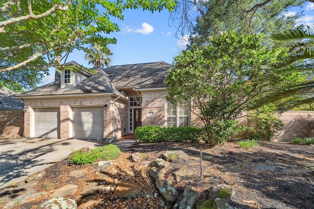 traditional home with concrete driveway, a garage, and brick siding