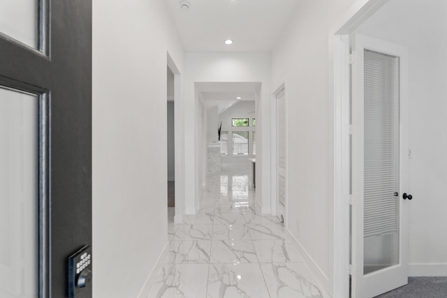 hallway with recessed lighting, baseboards, and marble finish floor