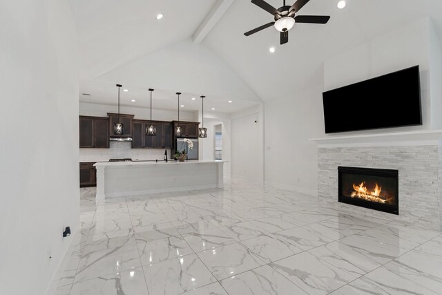 unfurnished living room with a ceiling fan, a tiled fireplace, lofted ceiling with beams, marble finish floor, and recessed lighting