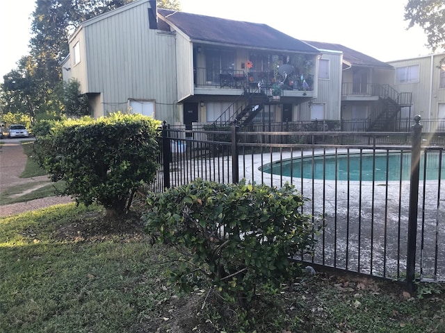 community pool featuring stairway and fence private yard