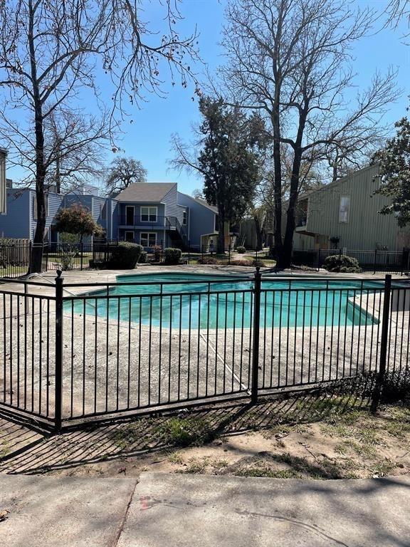 pool featuring fence and a residential view