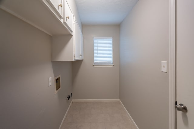 clothes washing area featuring light tile patterned floors, hookup for a washing machine, cabinet space, and baseboards
