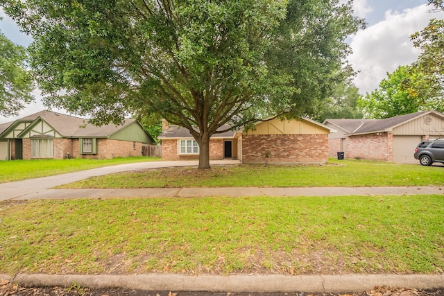 view of front of home with brick siding, a front lawn, and concrete driveway