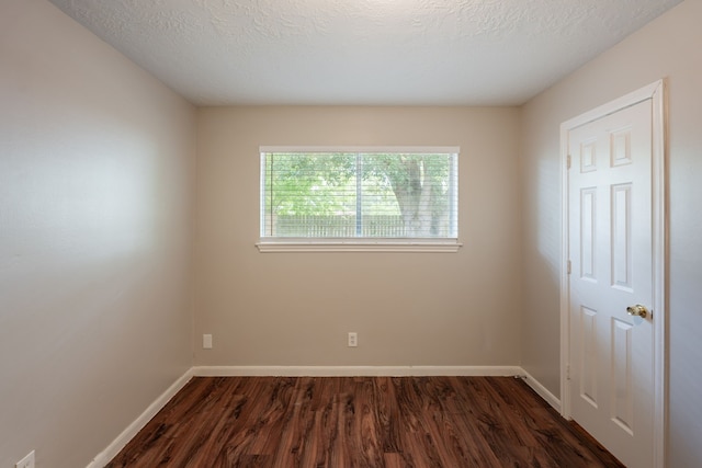 unfurnished room featuring baseboards and dark wood-type flooring