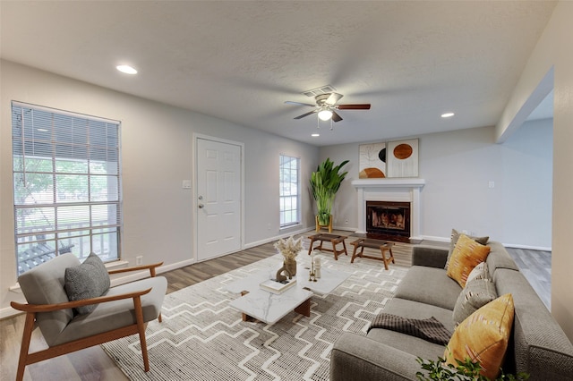 living area featuring recessed lighting, ceiling fan, wood finished floors, and baseboards