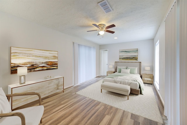 bedroom featuring visible vents, ceiling fan, wood finished floors, and baseboards