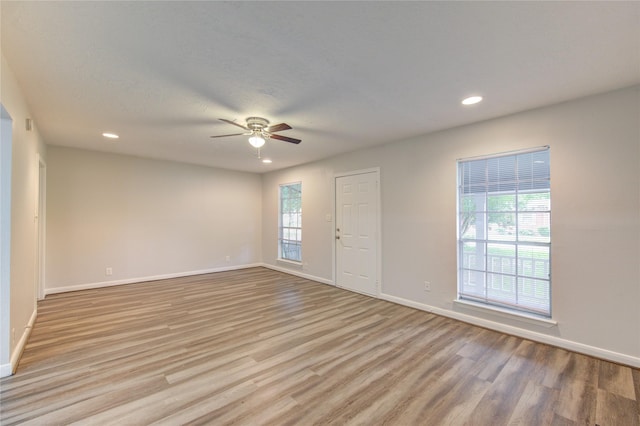 spare room with recessed lighting, ceiling fan, baseboards, and light wood-type flooring