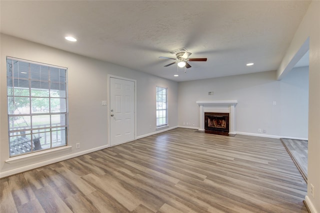 unfurnished living room with recessed lighting, ceiling fan, wood finished floors, and baseboards