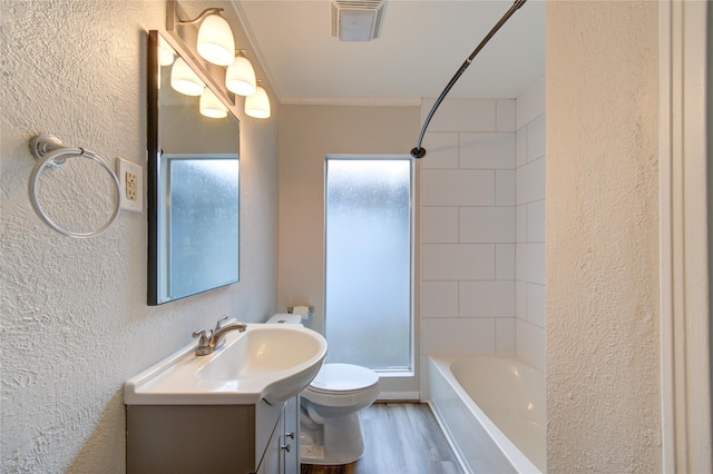 full bathroom with toilet, a textured wall, vanity, and ornamental molding