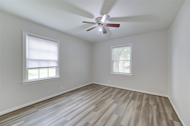 empty room with baseboards, wood finished floors, and a ceiling fan