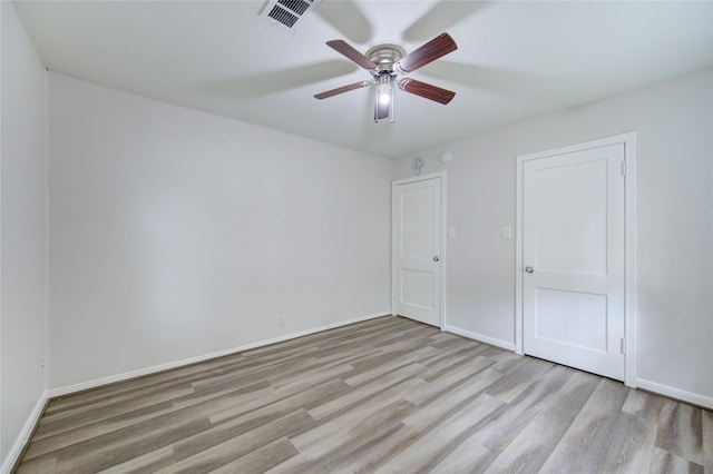 unfurnished bedroom with baseboards, visible vents, wood finished floors, and a ceiling fan