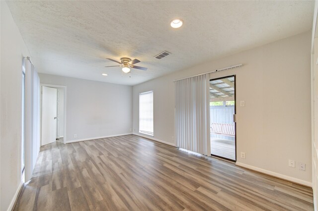 112 Begonia Ln, Highlands, TX 77562 - spare room featuring ceiling fan, healthy amount of natural light, wood finished floors, baseboards, and a textured ceiling