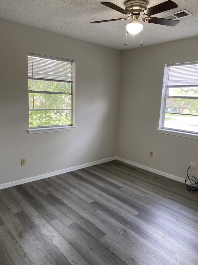 unfurnished room featuring a textured ceiling, a ceiling fan, and dark wood-type flooring