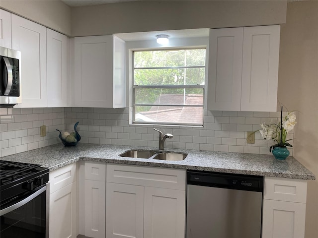 kitchen featuring white cabinetry, tasteful backsplash, appliances with stainless steel finishes, and a sink