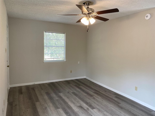 spare room featuring dark wood-style floors, a textured ceiling, ceiling fan, and baseboards