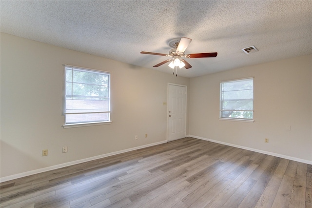 112 Begonia Ln, Highlands, TX 77562 - empty room featuring plenty of natural light, wood finished floors, a textured ceiling, ceiling fan, and baseboards