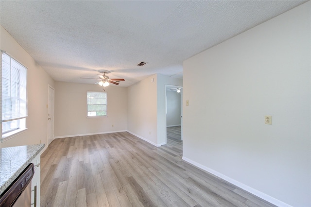 112 Begonia Ln, Highlands, TX 77562 - unfurnished living room with ceiling fan, light wood finished floors, a textured ceiling, and baseboards