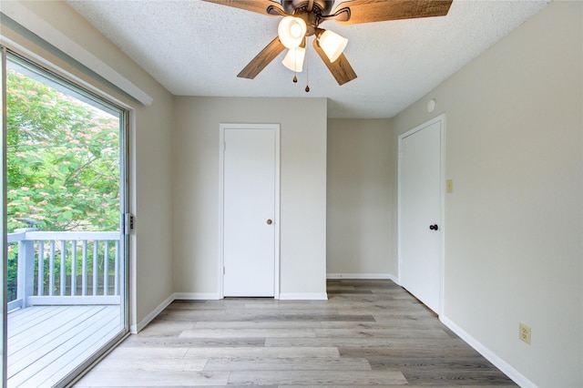 112 Begonia Ln, Highlands, TX 77562 - unfurnished bedroom featuring access to exterior, light wood-style floors, a textured ceiling, a ceiling fan, and baseboards