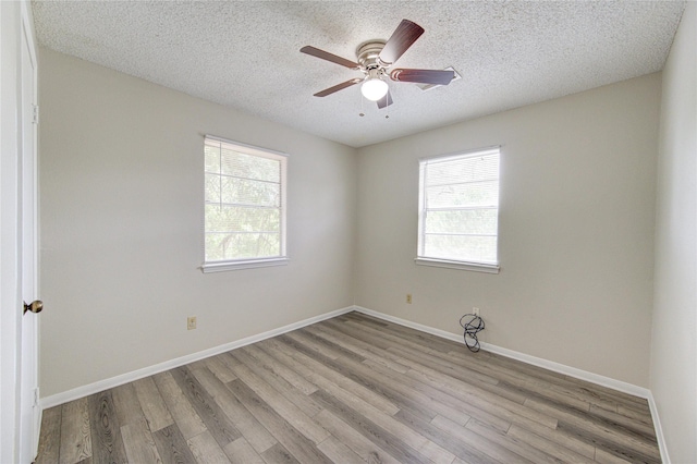 112 Begonia Ln, Highlands, TX 77562 - empty room with wood finished floors, a textured ceiling, a ceiling fan, and baseboards