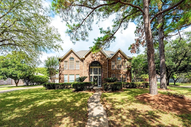 view of front of home featuring brick siding and a front lawn