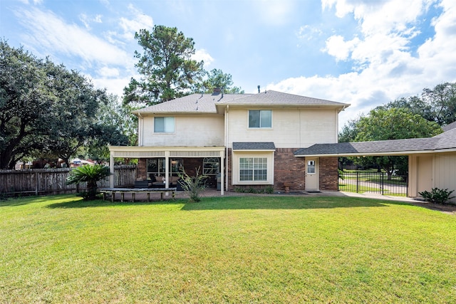 rear view of property with brick siding, a fenced backyard, a yard, and an attached carport