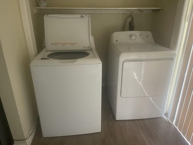 washroom featuring laundry area, wood finished floors, and washer and dryer