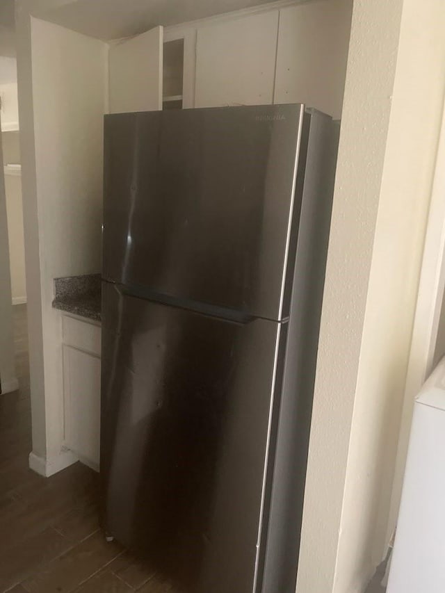 interior details featuring freestanding refrigerator, white cabinetry, and wood finished floors