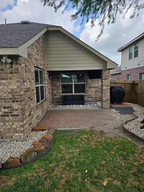 1318 Evermore Manor Ln, Houston, TX 77073 - back of house featuring brick siding and a patio area