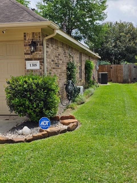 1318 Evermore Manor Ln, Houston, TX 77073 - view of side of home with an attached garage, brick siding, and central air condition unit