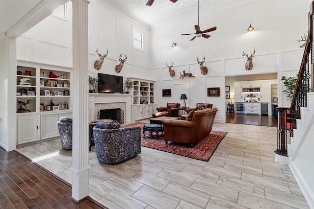 2215 Pecan Lake Dr, Richmond, TX 77406 - living area with a towering ceiling, stairway, a fireplace, a ceiling fan, and ornamental molding