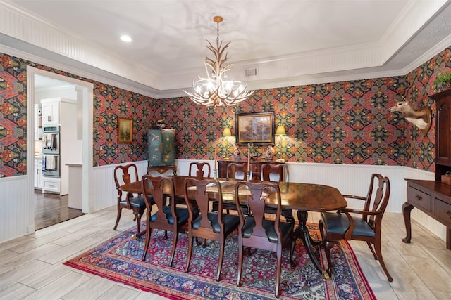 2215 Pecan Lake Dr, Richmond, TX 77406 - dining space featuring a wainscoted wall, a chandelier, wallpapered walls, and ornamental molding