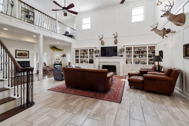 2215 Pecan Lake Dr, Richmond, TX 77406 - living room with a ceiling fan, a towering ceiling, a fireplace, and stairs