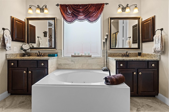 1509 Preserve Ln, Houston, TX 77089 - bathroom featuring marble finish flooring, a jetted tub, two vanities, and baseboards
