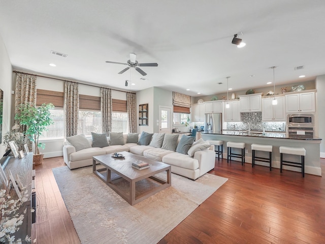 living area with visible vents, ceiling fan, hardwood / wood-style floors, and recessed lighting