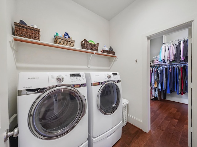laundry area with dark wood finished floors, baseboards, washing machine and clothes dryer, and laundry area