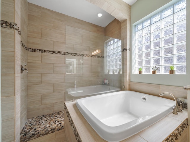 full bath featuring a healthy amount of sunlight, a tile shower, and a garden tub