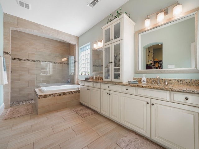 full bathroom featuring a sink, double vanity, visible vents, and a walk in shower