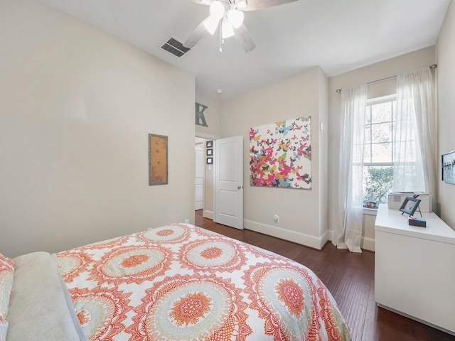 bedroom featuring dark wood-style floors, visible vents, a ceiling fan, and baseboards