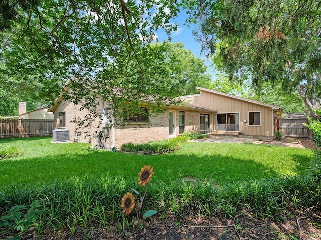 back of property featuring brick siding, a fenced backyard, a patio area, central air condition unit, and a yard