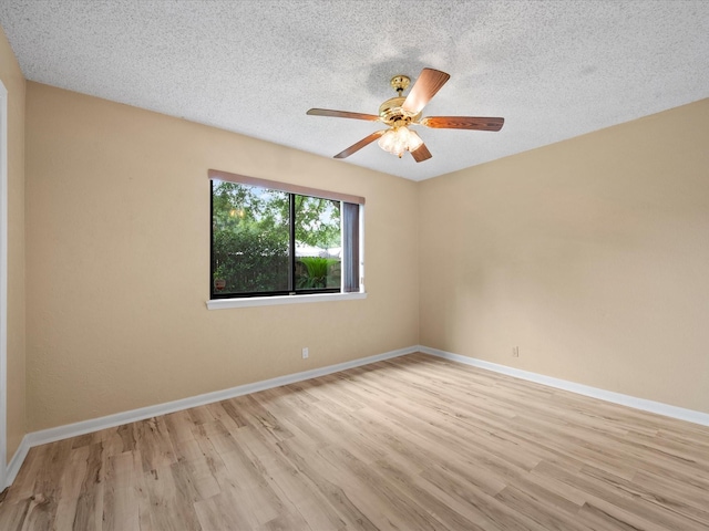 spare room with a textured ceiling, baseboards, ceiling fan, and light wood-type flooring